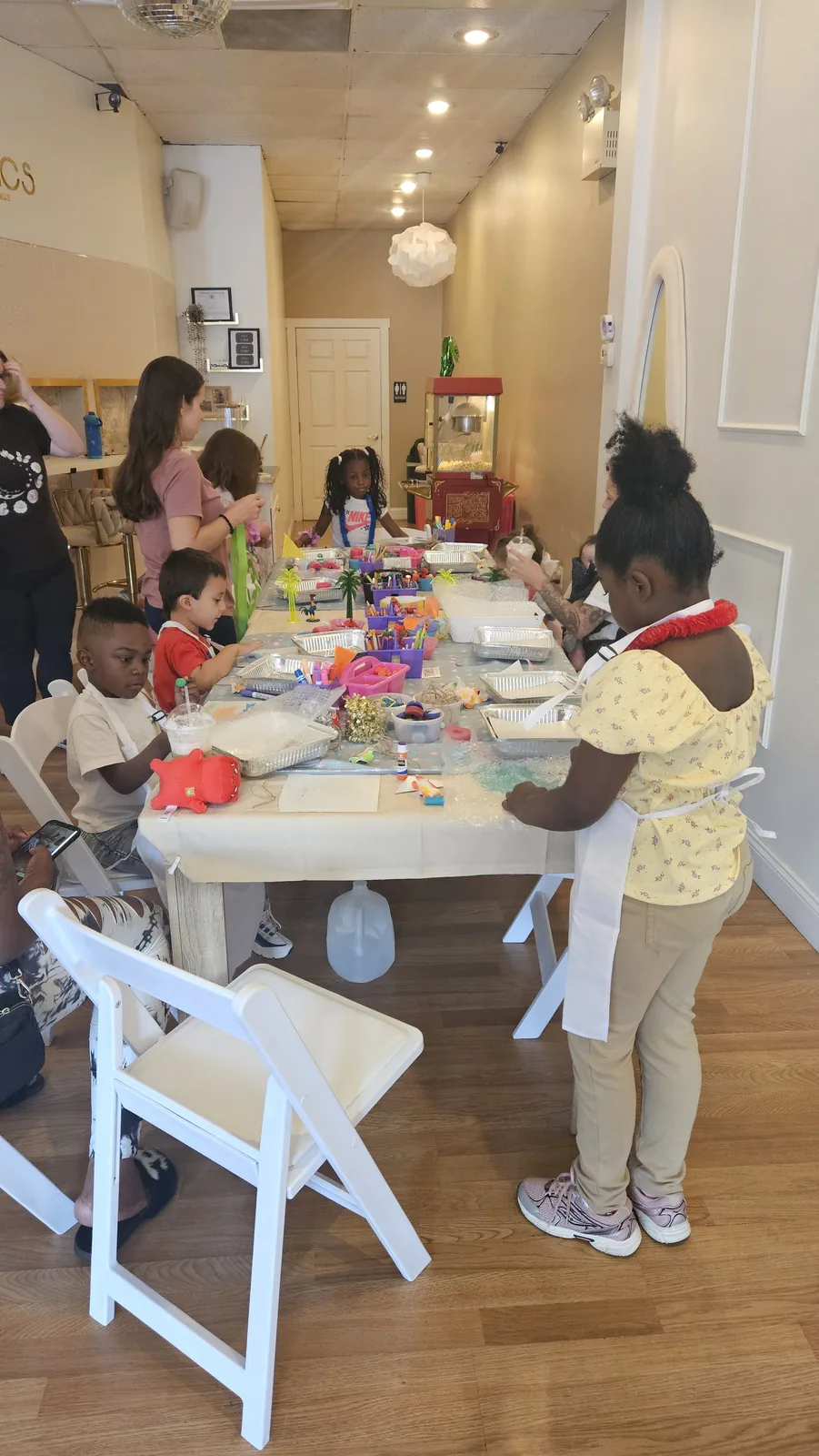 Children and grown-ups creating together at a colorful craft table in a bright community room